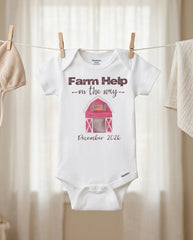 Baby onesie with 'Farm Help on the way' text and barn graphic, hanging on a clothesline.