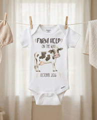 Baby onesie with cow illustration and text on a clothesline