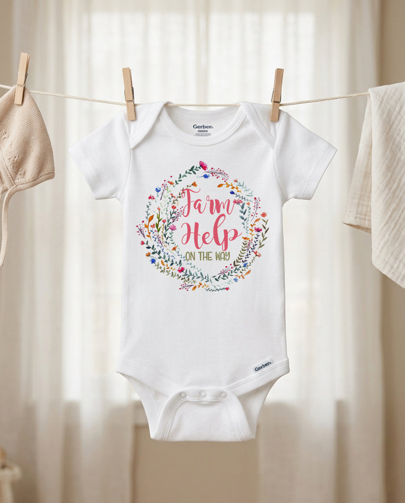 Baby onesie with floral wreath and text on a clothesline