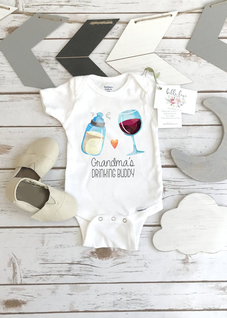 May include: A white baby onesie with a graphic of a baby bottle and a glass of wine. The text on the onesie reads 'Grandma's Drinking Buddy'.
