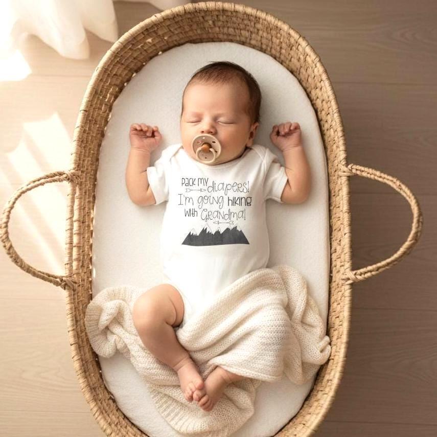"Pack my diapers! I'm going hiking with Grandma!"  (Or daddy, mommy, auntie, uncle, grandpa.)  This hiking baby bodysuit or t-shirt is perfect for your newest hiking buddy!  This design makes a great baby shower gift for the outdoorsy family that loves hiking! The design is Grey and the mountains are a chalkboard style.  (design is not black)  Please select the phrase you need on the drop down menu.