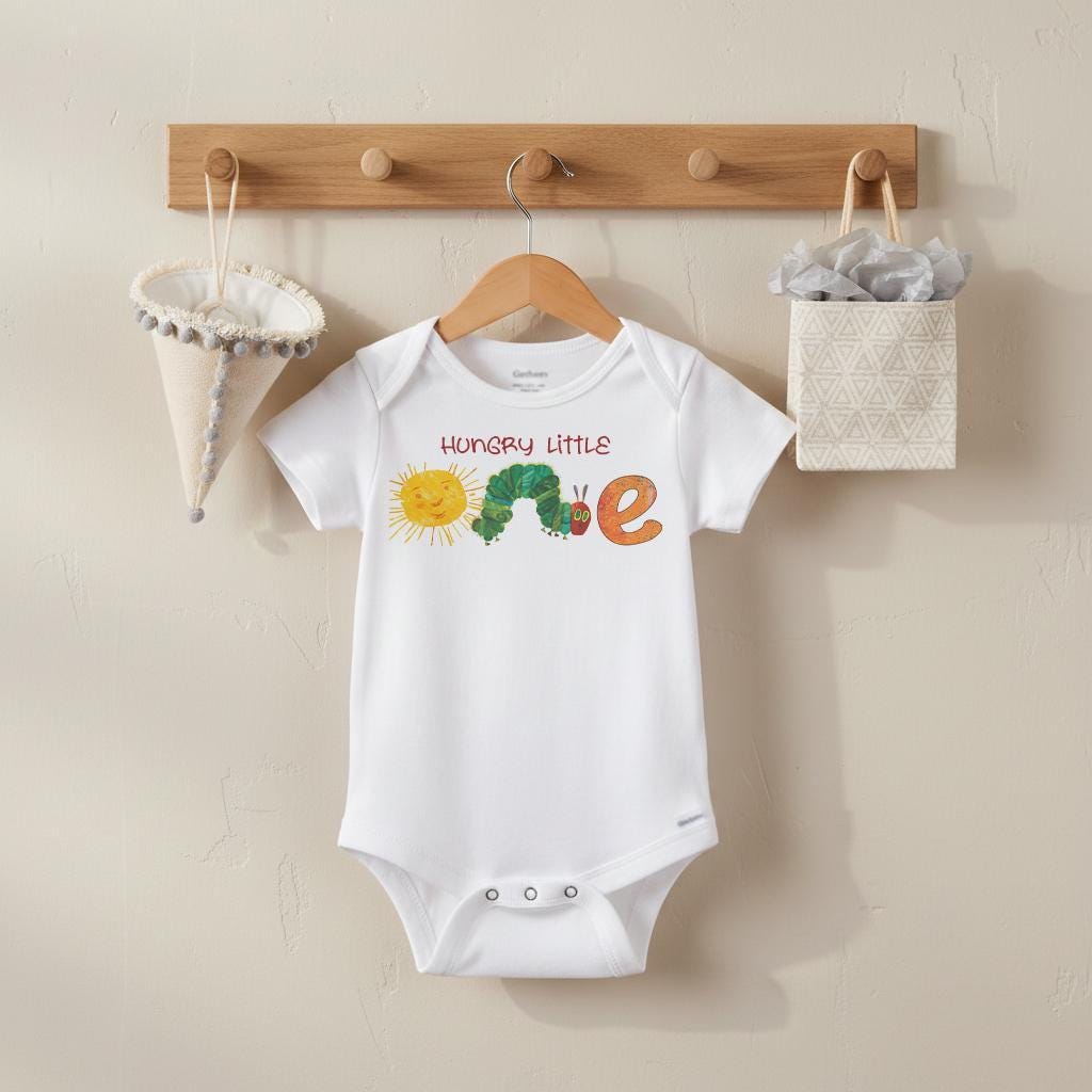 "Hungry Little One "  Celebrate your little one's first birthday with this cute caterpillar-themed onesie. Perfect for a day full of colorful fun, this design will make your baby the most charming little crawler at the party!