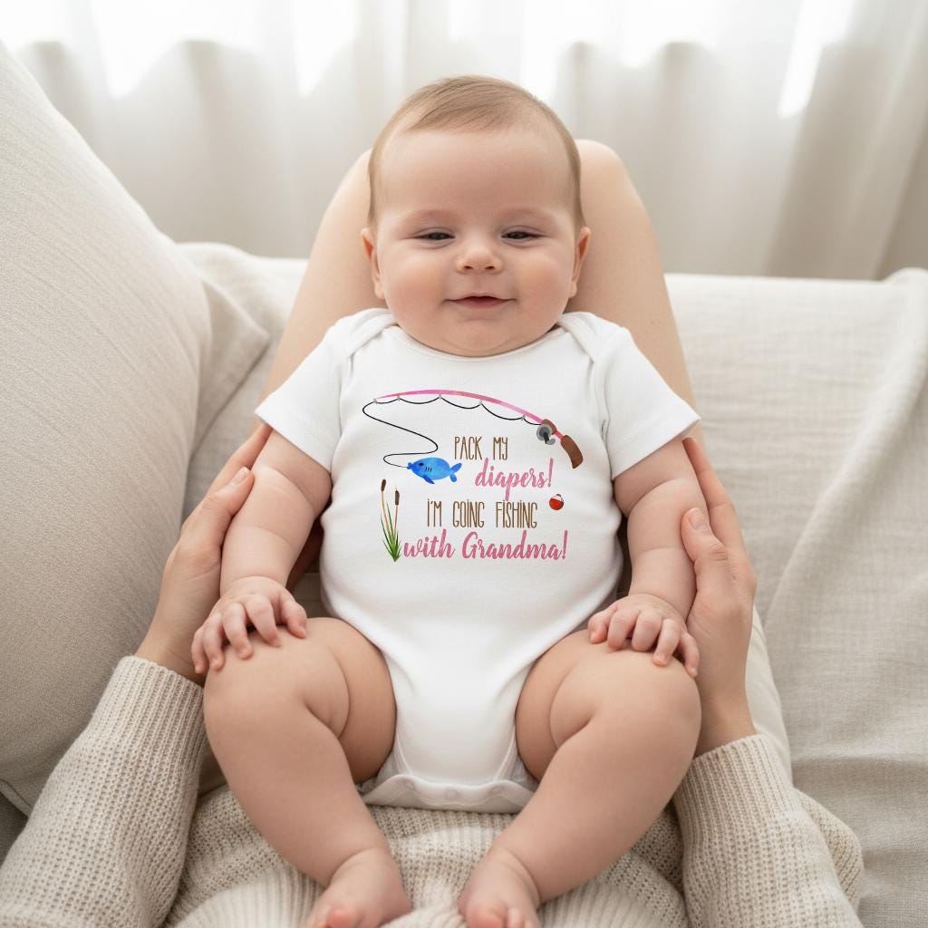 May include: A white short-sleeved baby bodysuit featuring a graphic of a pink fishing rod, a blue fish, and green reeds. The text printed on the front reads: Pack my diapers! I'm going fishing with Grandma! The design includes a small red bobber.