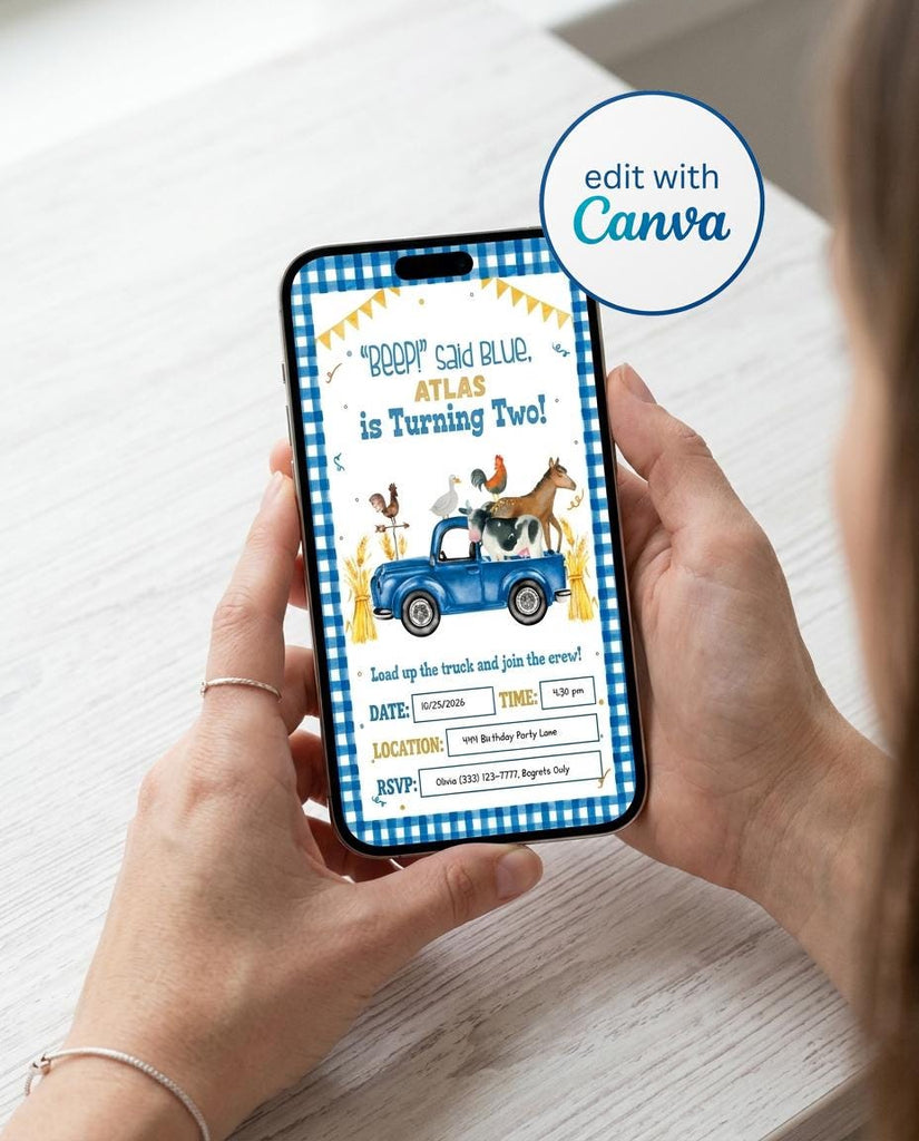 Hand holding a smartphone showing the phone version of an editable farm 2nd birthday invitation with a blue gingham border, yellow bunting, and a watercolor blue pickup truck carrying a cow, horse, rooster, and goose beside hay bales, with editable date, time, location, and RSVP fields and an edit with Canva badge.