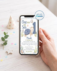 Hand holding a smartphone showing the phone version of an editable One-der the Sea turtle 1st birthday invitation with a watercolor sea turtle, polka dot number 1, and ocean creatures, next to a polka dot party hat, confetti, and eucalyptus, with an edit with Canva badge.