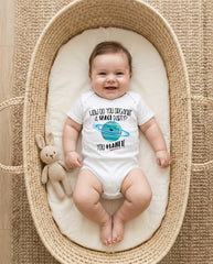 Baby in a Moses basket wearing a onesie with a space-themed design.