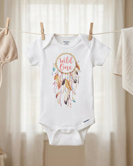 Baby onesie with 'Wild One' design hanging on a clothesline.